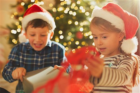 simsearch:632-06354055,k - Brother and sister in Santa hats opening Christmas gift Foto de stock - Sin royalties Premium, Código: 6124-08926915