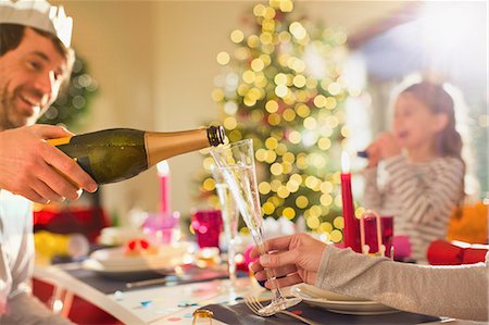 family eating dinner on special occasion - Husband pouring champagne for wife at Christmas dinner table Stock Photo - Premium Royalty-Free, Code: 6124-08926931