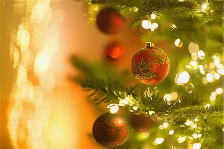 simsearch:6124-08926935,k - Red ornaments hanging from branch of Christmas tree with string lights Stock Photo - Premium Royalty-Free, Code: 6124-08926935