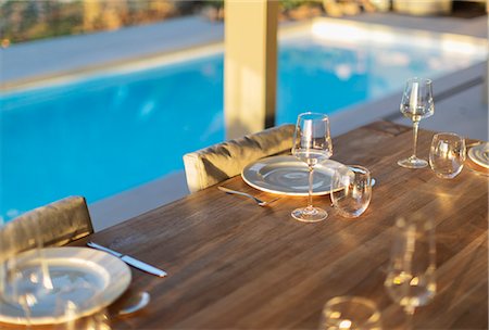 simsearch:6124-08927049,k - Placesettings on wood patio table at poolside Stock Photo - Premium Royalty-Free, Code: 6124-08927030