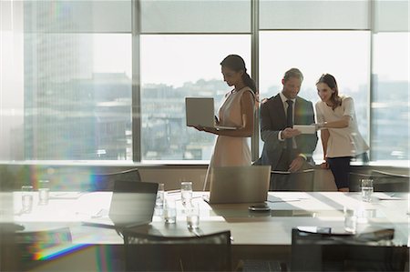 simsearch:6113-06899158,k - Business people working, using laptop and digital tablet in sunny conference room meeting Stock Photo - Premium Royalty-Free, Code: 6124-09056496