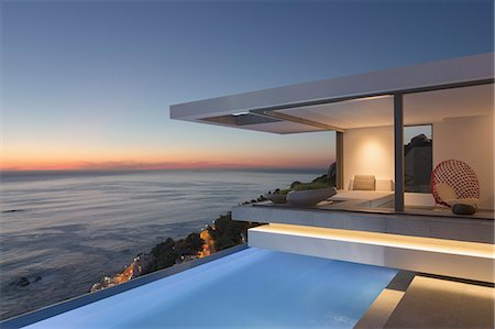 domicile - Illuminated modern, luxury home showcase exterior patio with lap pool and ocean view at twilight Photographie de stock - Premium Libres de Droits, Code: 6124-09099754
