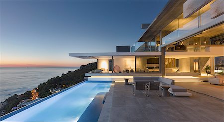Illuminated modern, luxury home showcase exterior patio with lap pool and ocean view at twilight Foto de stock - Sin royalties Premium, Código: 6124-09099763