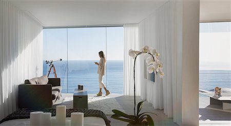 Woman standing on modern luxury home showcase balcony with sunny ocean view Stock Photo - Premium Royalty-Free, Code: 6124-09099760