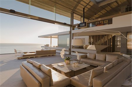 Sunny modern, luxury home showcase interior living room open to ocean view Photographie de stock - Premium Libres de Droits, Code: 6124-09099780