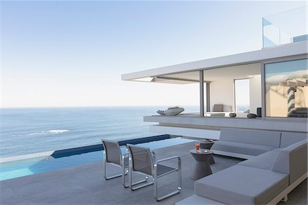 simsearch:6124-08704018,k - Modern, luxury home showcase exterior patio with lap pool and ocean view Stock Photo - Premium Royalty-Free, Code: 6124-09099793