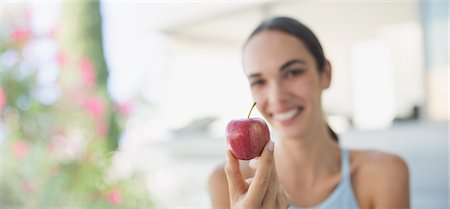 Portrait smiling brunette woman holding red apple Fotografie stock - Premium Royalty-Free, Codice: 6124-09099843