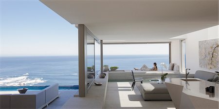 simsearch:6124-09099892,k - Woman relaxing on modern, luxury home showcase patio with sunny ocean view Stock Photo - Premium Royalty-Free, Code: 6124-09099869