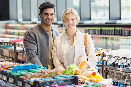 Portrait smiling young couple grocery shopping in market Stock Photo - Premium Royalty-Free, Code: 6124-09004789
