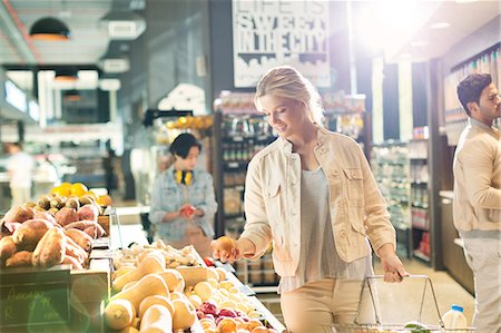 simsearch:6124-09004850,k - Young woman grocery shopping, browsing produce in market Stock Photo - Premium Royalty-Free, Code: 6124-09004848