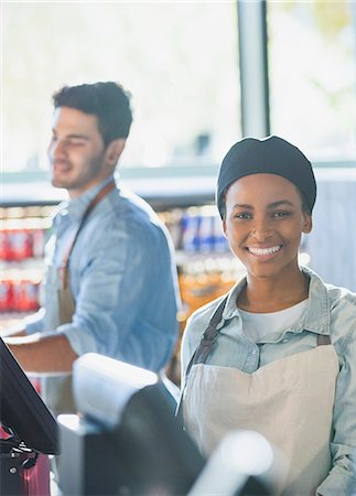 Portrait smiling young female cashier working at grocery store market checkout Stock Photo - Premium Royalty-Free, Code: 6124-09004851