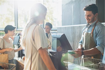 simsearch:6122-08229528,k - Male cashier helping female shopper at grocery store checkout Stock Photo - Premium Royalty-Free, Code: 6124-09004888