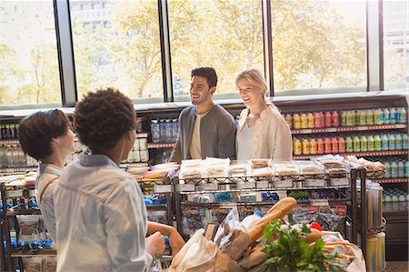simsearch:6118-09148131,k - Young friends talking in grocery store market Stock Photo - Premium Royalty-Free, Code: 6124-09004811