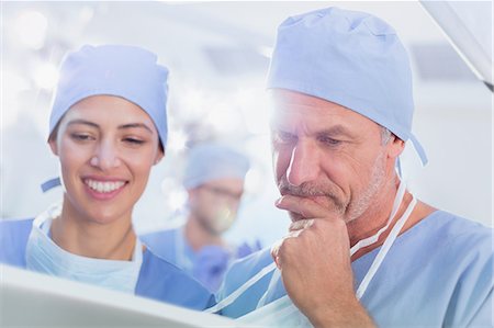 simsearch:6113-09027596,k - Surgeons reviewing paperwork in operating room Stock Photo - Premium Royalty-Free, Code: 6124-09026344