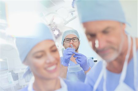 simsearch:649-08238207,k - Male anesthesiologist preparing anesthesia medicine in syringe in operating room Fotografie stock - Premium Royalty-Free, Codice: 6124-09026358