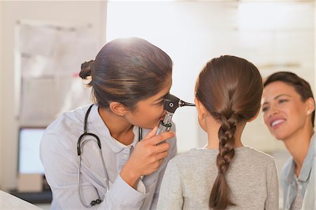 Female pediatrician using otoscope, checking ear of girl patient in examination room Photographie de stock - Premium Libres de Droits, Code: 6124-09026359