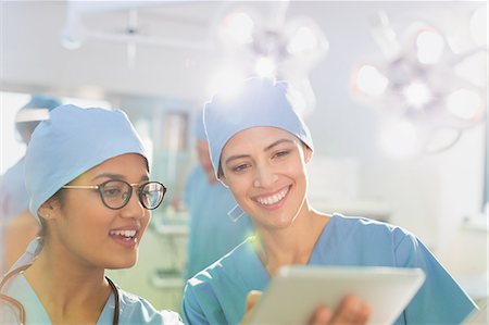 pflegen (fürsorge) - Female surgeons using digital tablet, talking in operating room Stockbilder - Premium RF Lizenzfrei, Bildnummer: 6124-09026314