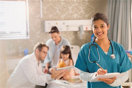 simsearch:632-08993554,k - Portrait confident female nurse taking notes on medical record while doctor shows digital tablet to girl patient in hospital Stock Photo - Premium Royalty-Free, Code: 6124-09026323