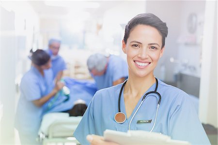 patients and doctors looking at camera hallway - Portrait smiling, confident female surgeon with clipboard in hospital corridor Stock Photo - Premium Royalty-Free, Code: 6124-09026335