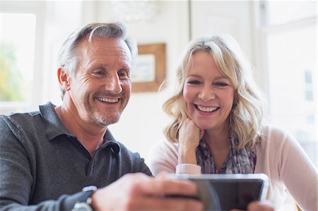 skype - Smiling mature couple using smart phone Foto de stock - Sin royalties Premium, Código: 6124-09143714
