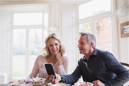 simsearch:6108-07969489,k - Mature couple using smart phone at breakfast table Foto de stock - Sin royalties Premium, Código: 6124-09143727