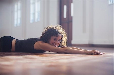 simsearch:6124-09159838,k - Smiling, carefree young female dancer stretching on dance studio floor Foto de stock - Sin royalties Premium, Código: 6124-09159908