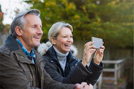 simsearch:6124-09167251,k - Happy mature couple using camera phone in park Stock Photo - Premium Royalty-Free, Code: 6124-09167265