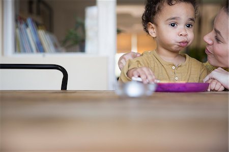 simsearch:6113-08947220,k - Mother watching cute, innocent boy eating at table Photographie de stock - Premium Libres de Droits, Code: 6124-09167297