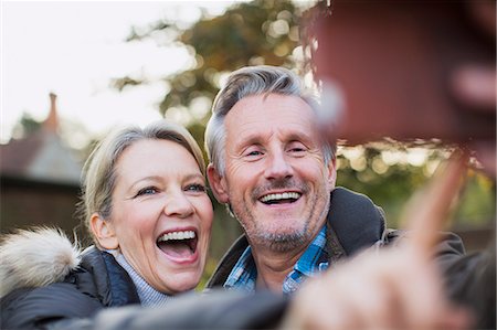 Happy, playful mature couple taking selfie Stock Photo - Premium Royalty-Free, Code: 6124-09167216