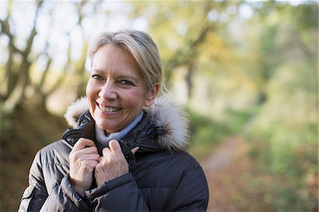 smiling woman portrait vitality - Portrait smiling, confident mature woman in parka in woods Stock Photo - Premium Royalty-Free, Code: 6124-09167230
