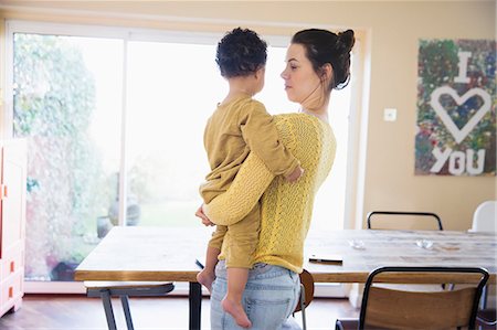 simsearch:6113-08947220,k - Mother holding baby son in dining room Photographie de stock - Premium Libres de Droits, Code: 6124-09167355