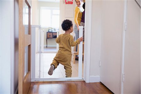 simsearch:6119-07845671,k - Cute baby boy balancing in doorway Fotografie stock - Premium Royalty-Free, Codice: 6124-09167363