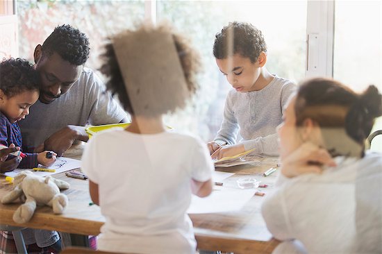 Young family coloring at dining table Stock Photo - Premium Royalty-Free, Image code: 6124-09167376