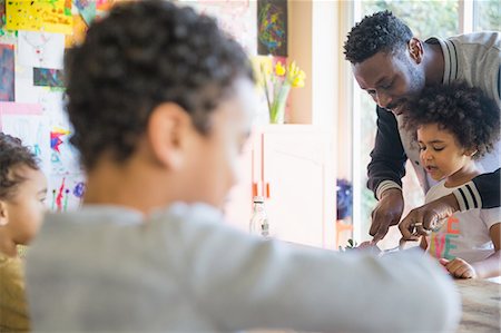 simsearch:6108-06167425,k - Father helping cut food for daughter at table Stock Photo - Premium Royalty-Free, Code: 6124-09167313