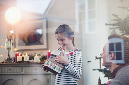 Eager girl gathering Christmas gifts Stock Photo - Premium Royalty-Free, Code: 6124-09177885