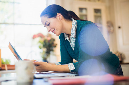 simsearch:6124-08743365,k - Woman using laptop in kitchen Foto de stock - Sin royalties Premium, Código: 6124-09177919