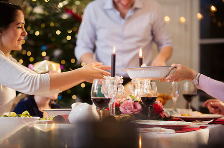 simsearch:6124-09177991,k - Family passing food, enjoying candlelight Christmas dinner Stock Photo - Premium Royalty-Free, Code: 6124-09177932