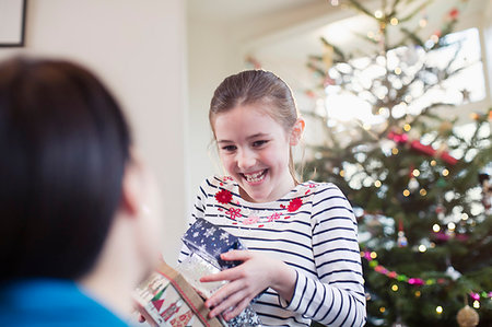 Happy, eager girl gathering Christmas gifts Foto de stock - Sin royalties Premium, Código: 6124-09177938