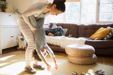 energetic mother - Playful mother and daughter in sunny living room Stock Photo - Premium Royalty-Free, Code: 6124-09178063