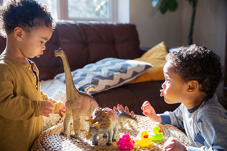 Toddler brothers playing with dinosaur and rubber duck toys Stock Photo - Premium Royalty-Free, Code: 6124-09178016