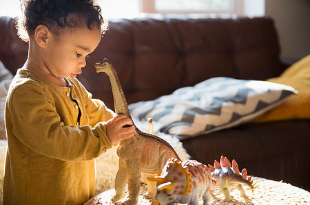 Innocent boy playing with dinosaur toys Photographie de stock - Premium Libres de Droits, Code: 6124-09178036