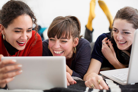 simsearch:6124-09188475,k - Laughing young women friends hanging out, enjoying digital tablet and laptop on bed Foto de stock - Sin royalties Premium, Código: 6124-09188485