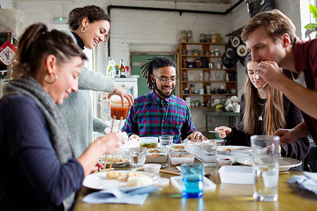 simsearch:6124-09188534,k - Young roommate friends enjoying takeout food at kitchen table in apartment Foto de stock - Sin royalties Premium, Código: 6124-09188525