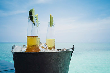 fruits and water - Lime slices in beer bottles on ice on tranquil ocean beach, Maldives, Indian Ocean Stock Photo - Premium Royalty-Free, Code: 6124-09188693