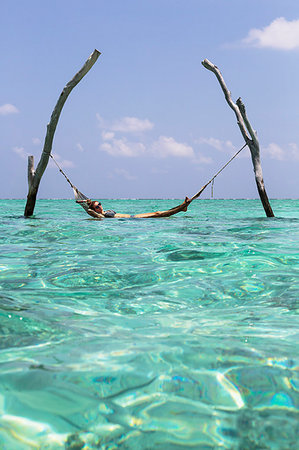 simsearch:6124-09188617,k - Young woman laying in hammock over tranquil blue ocean, Maldives, Indian Ocean Stockbilder - Premium RF Lizenzfrei, Bildnummer: 6124-09188629