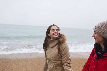 Mother and daughter in warm clothing walking on winter ocean beach Stock Photo - Premium Royalty-Free, Code: 6124-09188852
