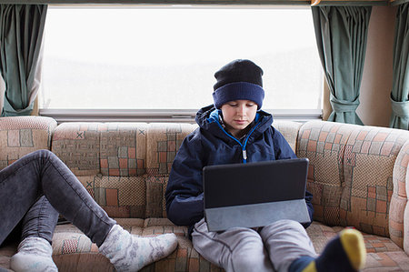 Teenage boy using digital tablet in motor home Stock Photo - Premium Royalty-Free, Code: 6124-09188869