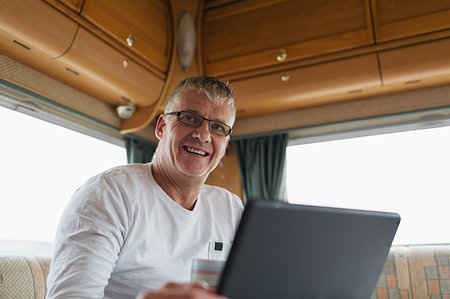 simsearch:6113-07565151,k - Smiling, confident man drinking coffee and using digital tablet in motor home Stock Photo - Premium Royalty-Free, Code: 6124-09188891