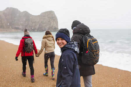 portrait of siblings at the beach - Portrait happy boy walking on snowy winter ocean beach with family Photographie de stock - Premium Libres de Droits, Code: 6124-09188814