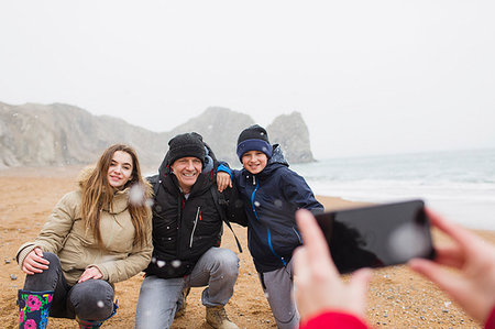 simsearch:6113-08947330,k - Happy family posing for photograph on snowy winter beach Foto de stock - Sin royalties Premium, Código: 6124-09188835